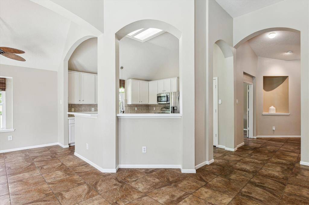 Featuring arched walkways and elevated bar seating, the kitchen offers a perfect spot for casual dining.