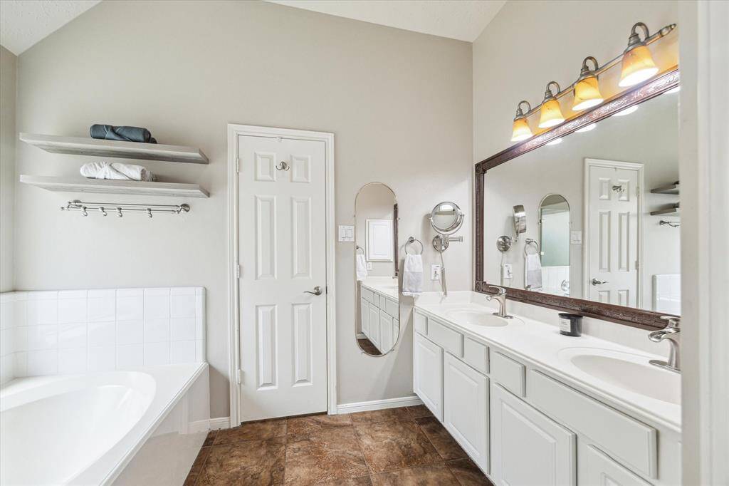 The primary bathroom also features a relaxing soaking tub with towel rack storage above.