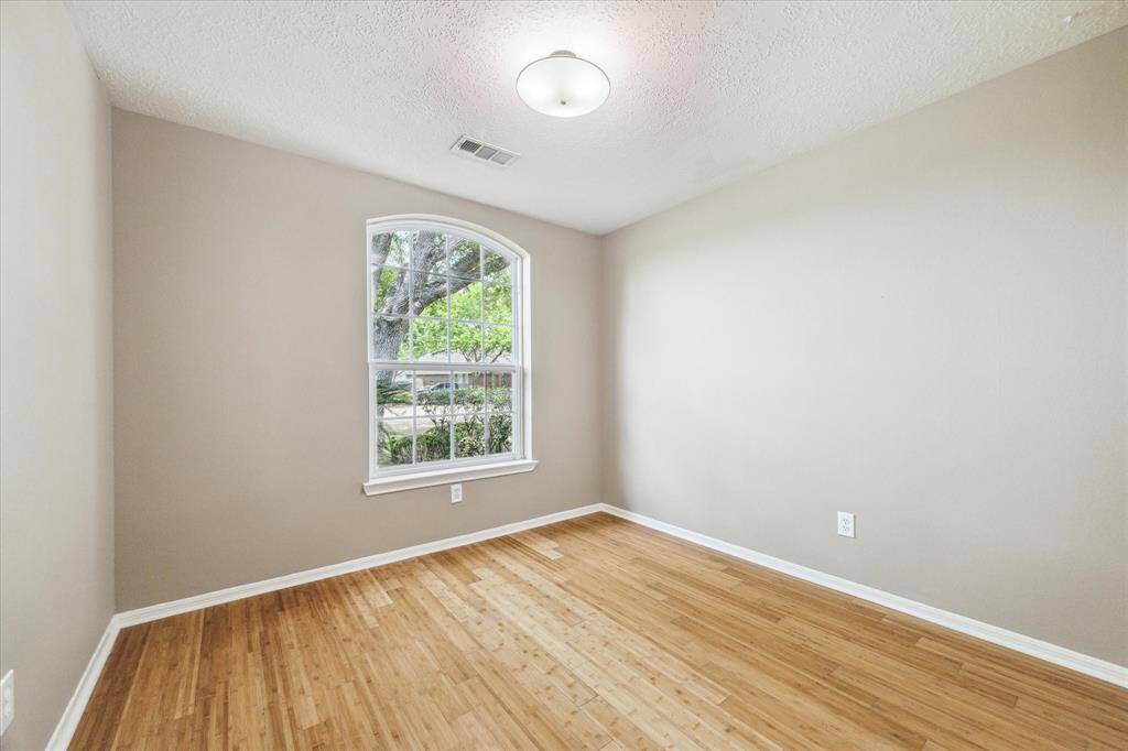 The third bedroom also features bamboo wood flooring, fresh paint, a light fixture, and is located at the front of the home.