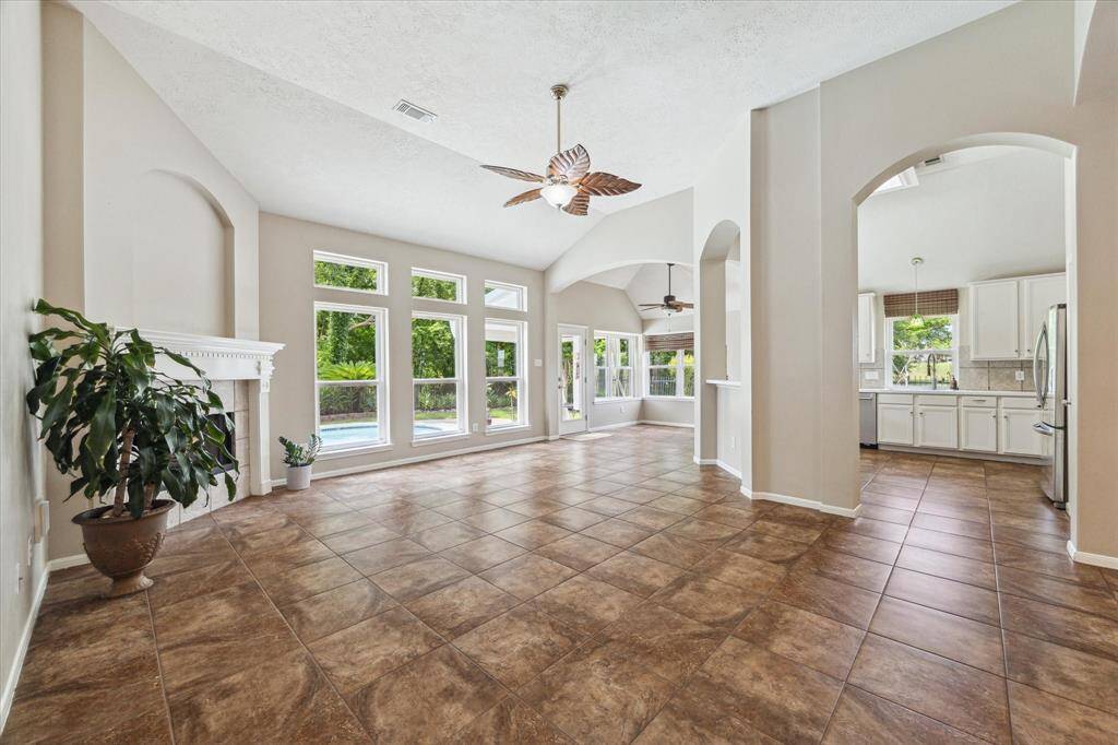Gorgeous view of the living space, filled with natural light and offering a glimpse of the backyard pool and lush greenery.