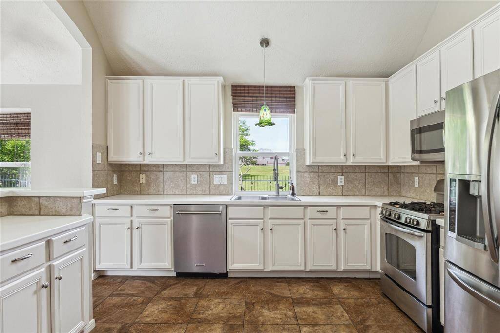 A view of the kitchen showing the abundance of counter space, newly replaced dishwasher, and storage cabinets above and below.