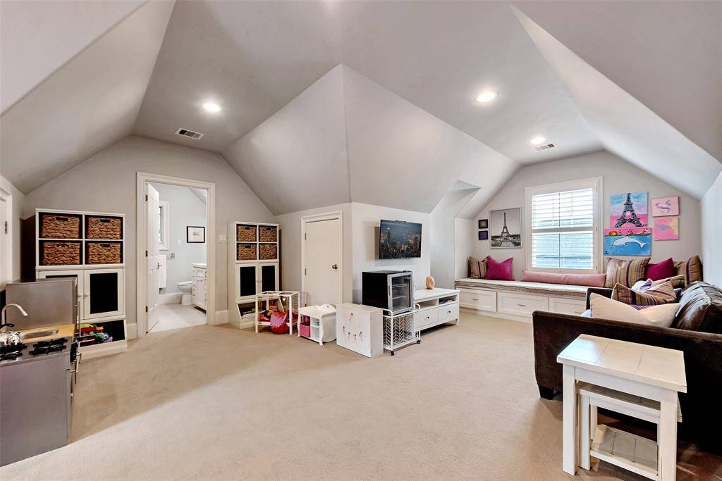 This spacious third-floor game room offers versatile fun with built-in window seating and custom storage. Vaulted ceilings add architectural charm, while the connected full bath make it perfect for kids or a spacious guest suite.