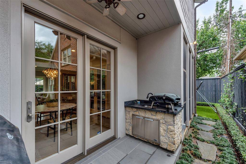 This outdoor kitchen is both stylish and functional, featuring a outdoor grill and sink set in stonework with granite counters. Tucked off the kitchen and breakfast area, it's perfect for al fresco cooking and easy entertaining.
