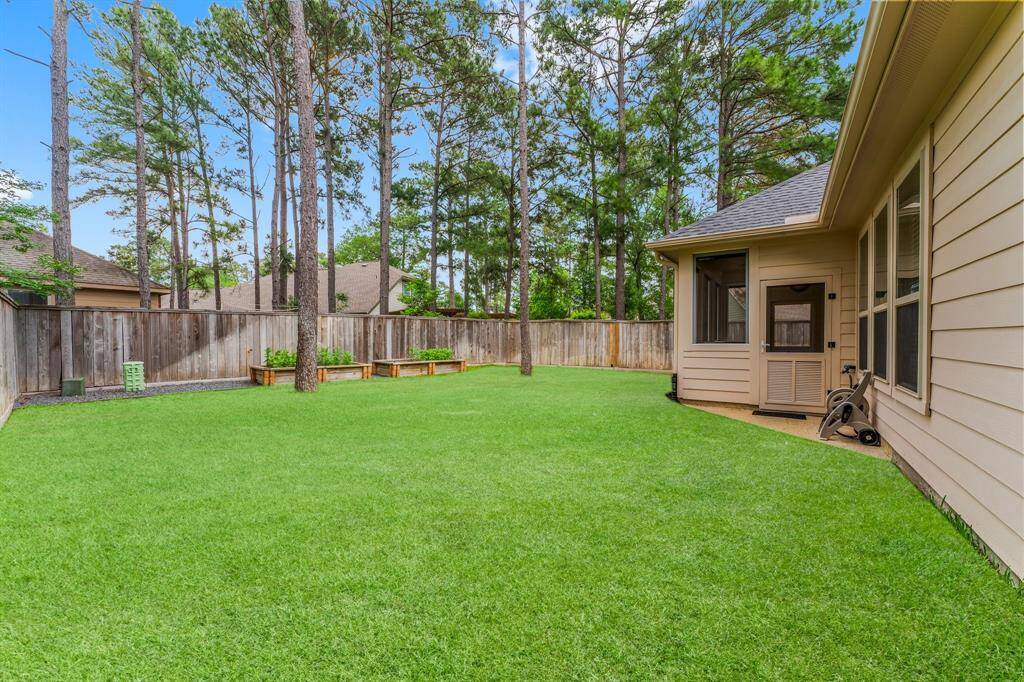 The expansive backyard features lush landscaping and plenty of space for play, pets, or a future pool—surrounded by a privacy fence and mature trees for a serene setting.