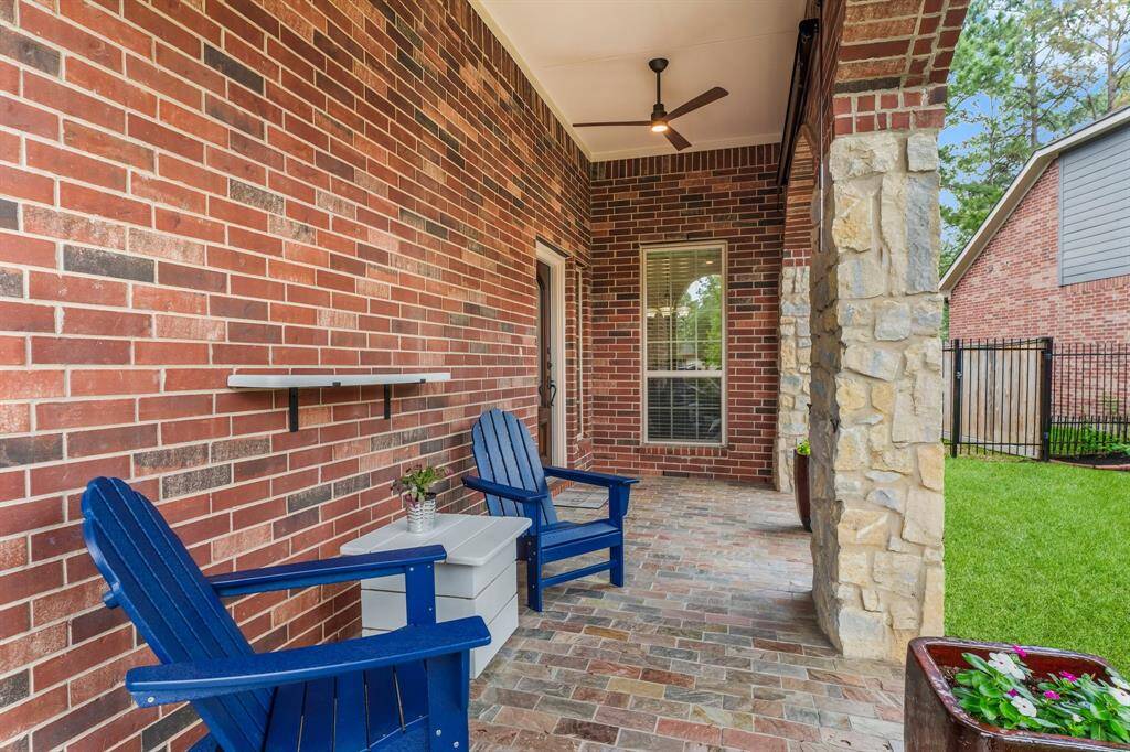 The covered front porch is a true extension of the home’s charm, with brick pavers underfoot and ceiling fans overhead for comfort year-round. Solar shades provide relief from the sun and privacy. Whether sipping coffee or greeting neighbors, this space invites peaceful outdoor living beneath the shelter of stone archways.