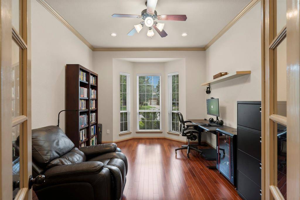 Framed by French doors and bathed in natural light from the front-facing bay window, this flexible space is currently used as a home office. Rich hardwood floors, crown molding, and recessed lighting add polish, making it an inspiring environment for productivity or relaxation.