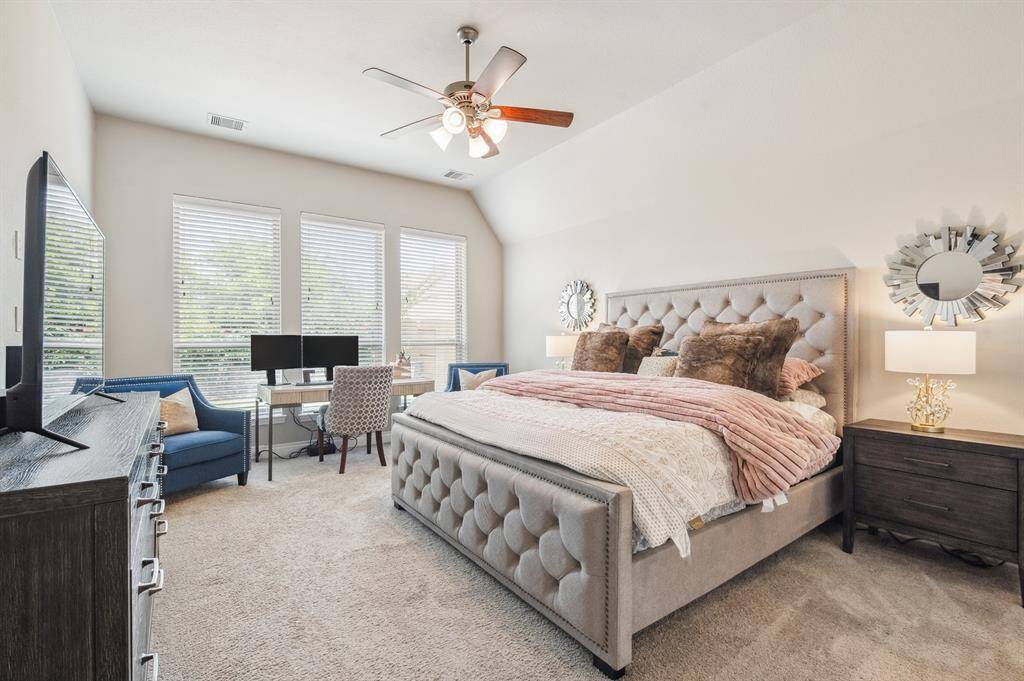 The spacious primary suite features high ceilings and large windows that fill the room with natural light and a sense of tranquility. Designed for comfort and elegance, it offers a serene retreat with a luxurious, airy feel.