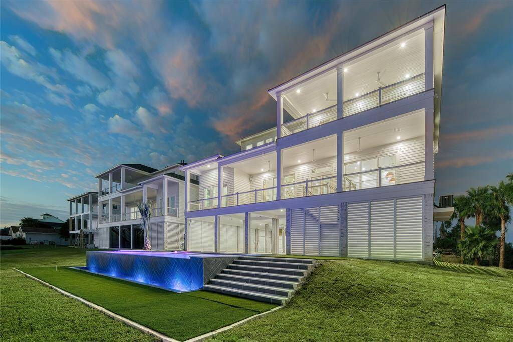 Modern multi-level home with expansive balconies, elegant lighting, and a sleek infinity pool. The exterior is stylish with spacious outdoor areas, ideal for relaxation and entertaining.