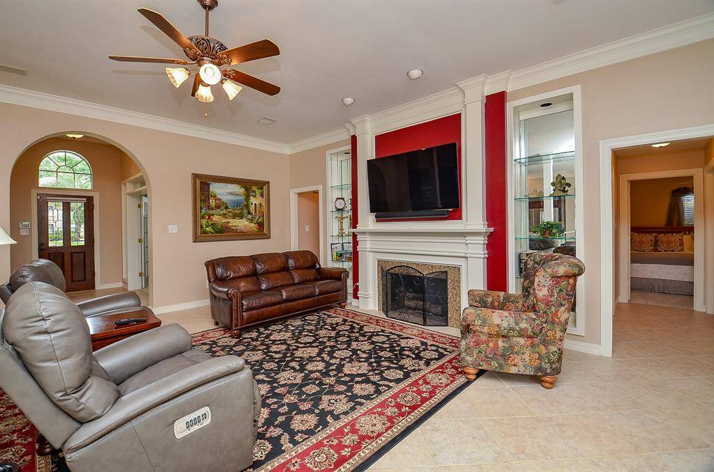 The beauty and versatility of the timeless open floor plan design concept is clearly seen here, with wide open, airy space that extends all the way, to and from, the front entrance, left. The good looking built-in fireplace is sure to be the star of holiday entertaining, with a warm fire delighting guests.
