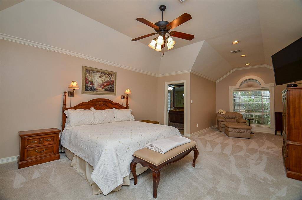 Your spectacular primary suite is surely your private place of peace and repose, with high ceiling, delicate recessed lighting in the cozy bonus alcove under a gorgeous arched, detailed window; tremendous wall and floor space, and ensuite bath peeking out, up center.