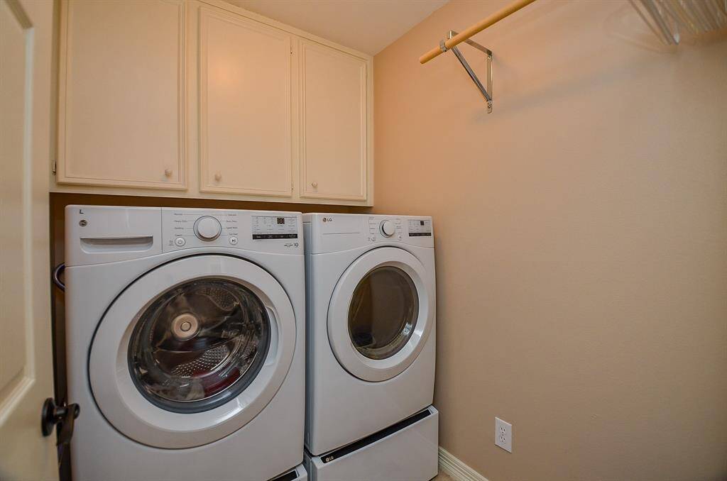 Sizeable dual laundry appliances are at home in the utility room, with storage and hanging rod, above.