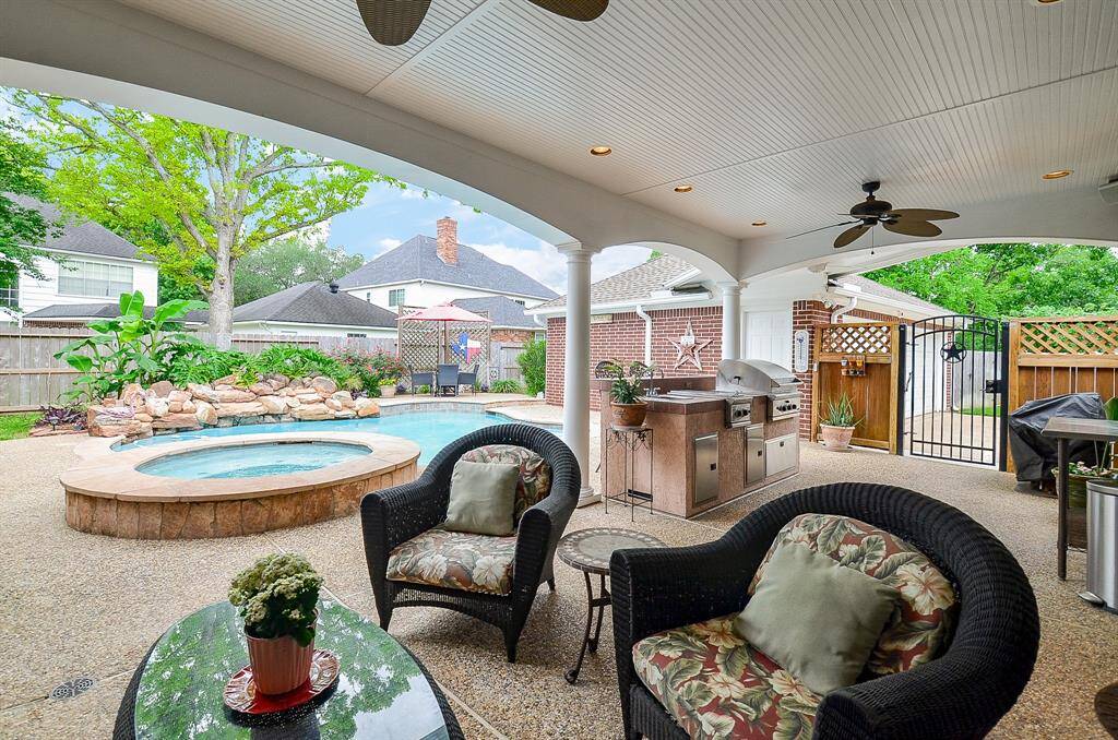 What an incredibly rich, yet soothing vibe fills the huge, covered patio, complete with its full outdoor kitchen, and tranquil view of pool, spa and lush native greenery.