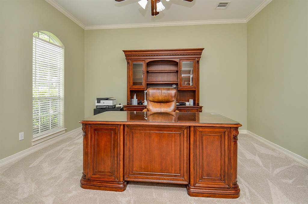 Relaxing tones on walls with crown molding invite us into this spacious room that welcomes sizeable pieces and accents.