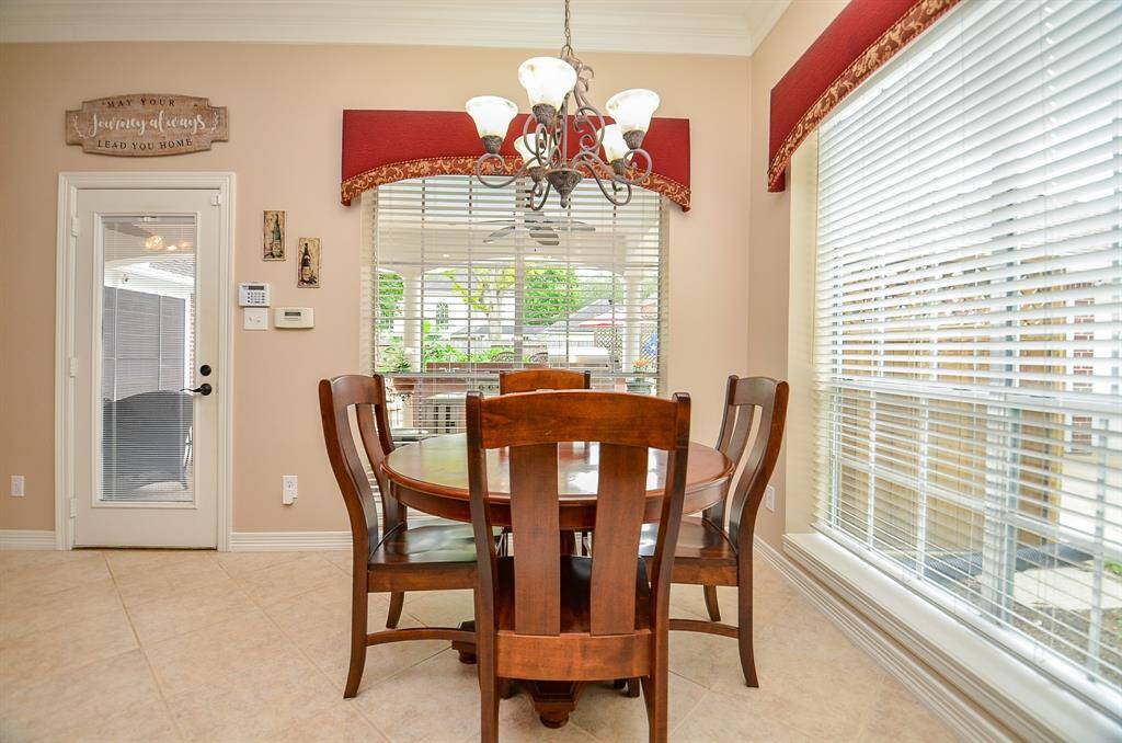 The roomy breakfast/casual dining nook in the bright kitchen, is surrounded with walls of windows and easy access to the patio door.