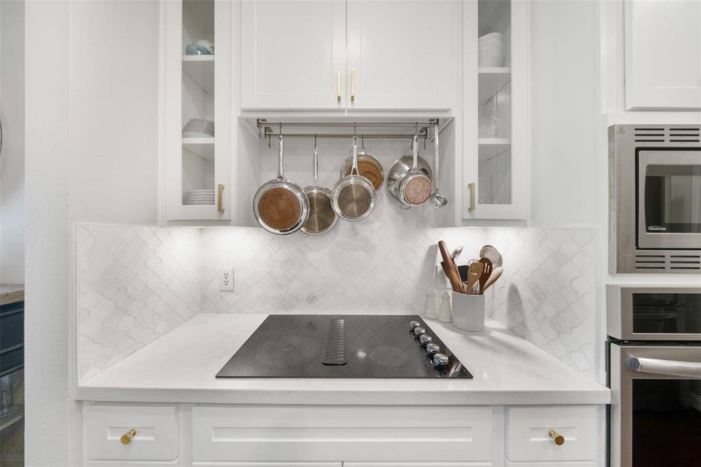 The striking backsplash is a focal point in this kitchen, and you will love the quartz countertops and soft-close drawers.