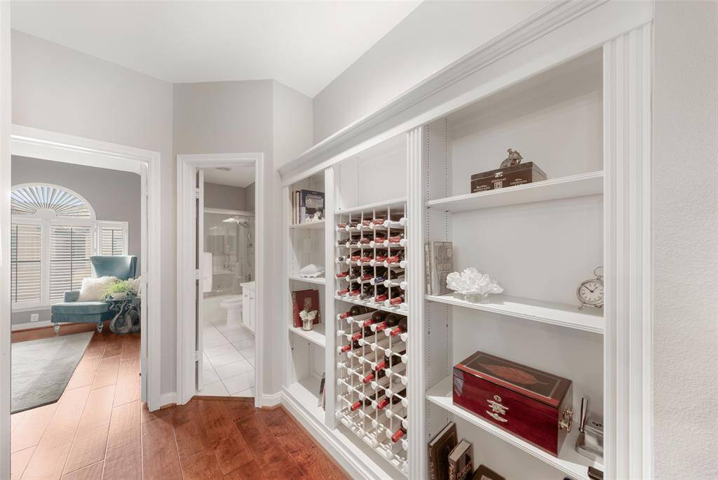 In the hallway is a creative use of space with these decorative and practical built-in shelves and wine racks.