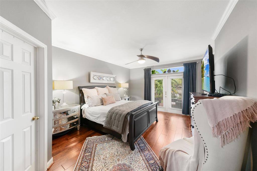 The primary bedroom is on the first level.  In this room, you will be amazed and pleased at what a great space it is.  The double doors, complete with plantation shutters, lead out to the townhome's patio.