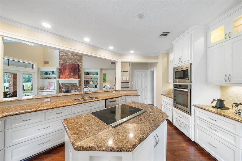 An open layout with views into the living area, featuring a brick fireplace and built-in shelving.