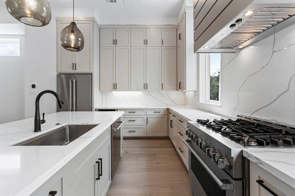 Closer up view of this dreamy kitchen.  Stainless steel JennAir appliance package includes: a large counter depth french door fridge/freezer, a 36’’ gas professional style range, an under counter microwave drawer and a dishwasher.
