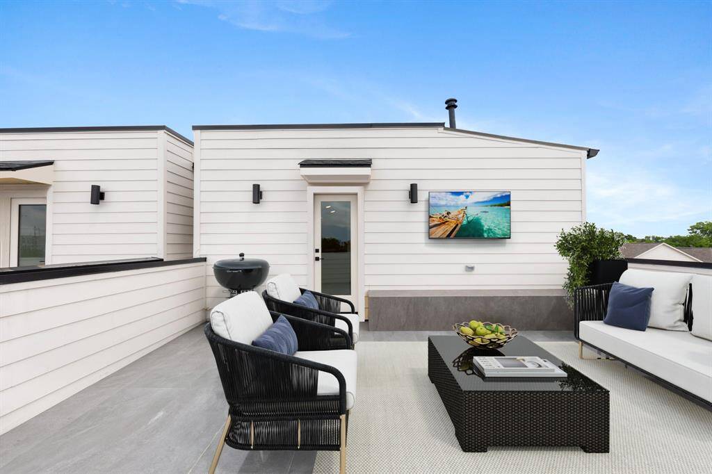 Another angle of this incredible rooftop deck featuring a plumbing and a gas line for a future outdoor kitchen, TV wiring, and a built-in bench seat. Note: this photo has been virtually staged.