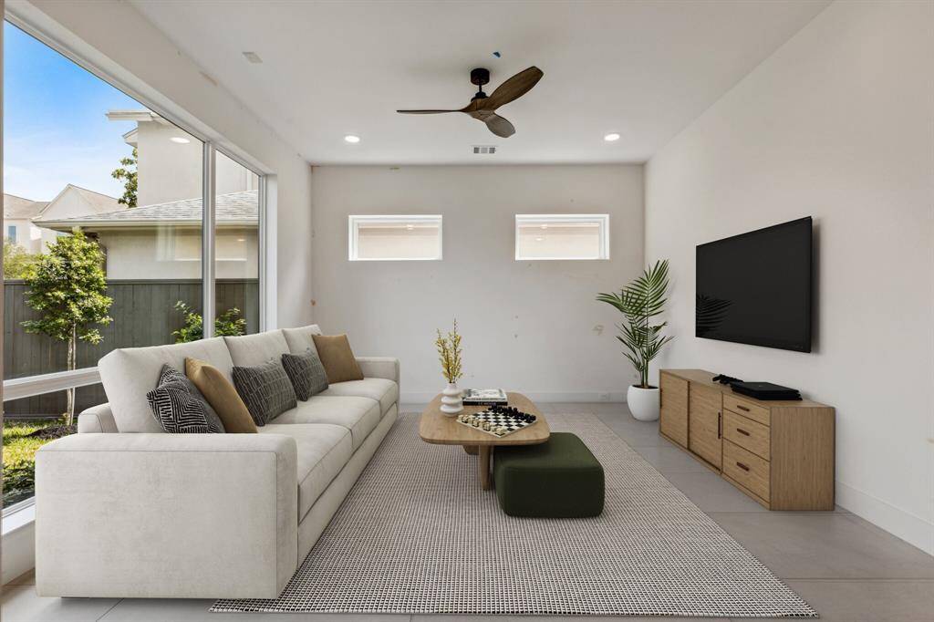 Welcome to this rare first-floor flex/living room! With endless possibilities, it can serve as a game room, home office, or formal living. The expansive 8x12 Sierra Pacific commercial-grade window floods the room w/ natural light, while the sleek 24x48 porcelain tile floor adds a modern touch. Plus, there's a convenient electrical outlet for your TV as well as a Visual Comfort fan. Note: this photo has been virtually staged.