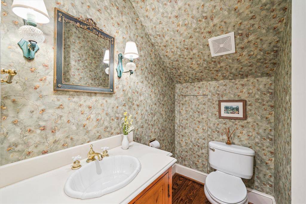 Half bathroom with antique sconces and accent walls.