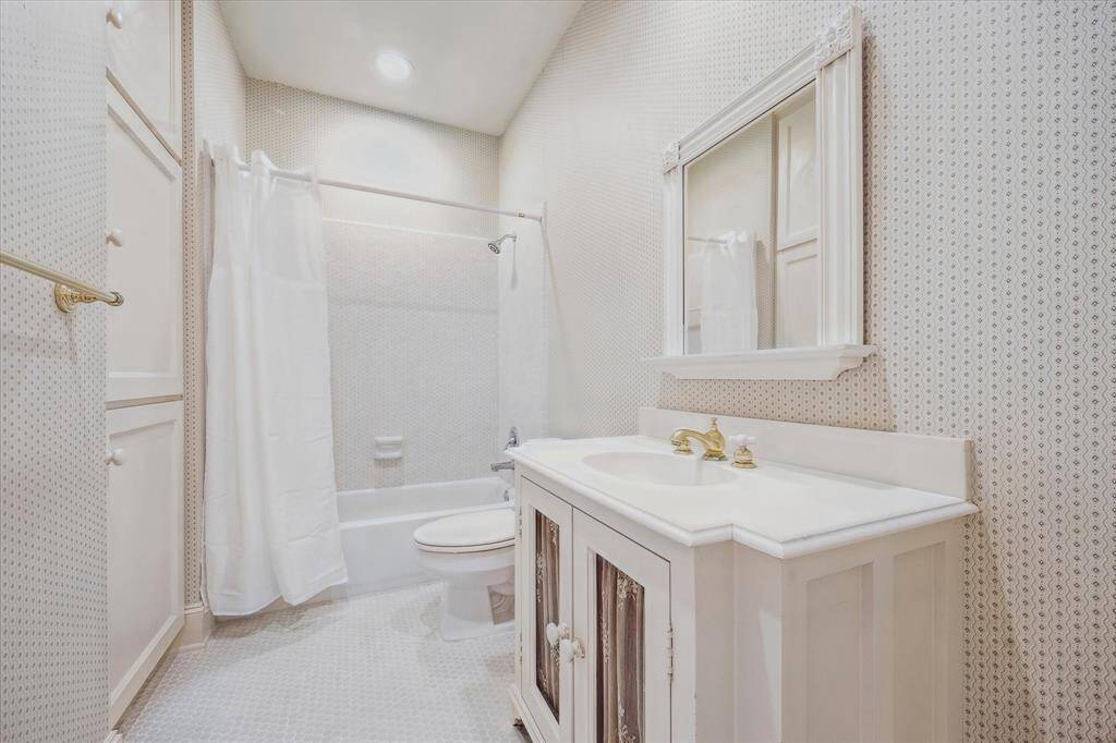 Secondary bathroom with tub and shower combination, neutral tones and tile flooring.