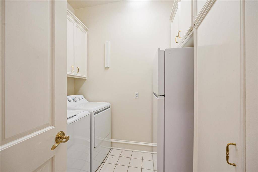Spacious laundry room downstairs with great storage options and an additional refrigerator.