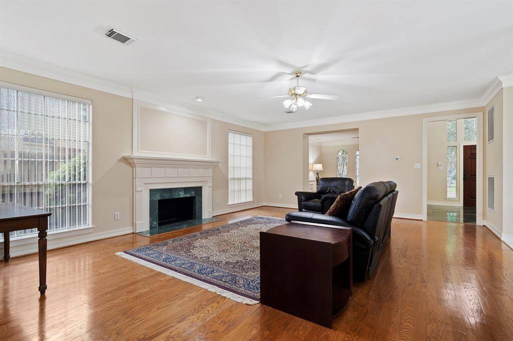 Expansive windows and a charming fireplace come together to blend timeless style with warmth and sophistication, creating a cozy yet refined space for gathering and relaxation.