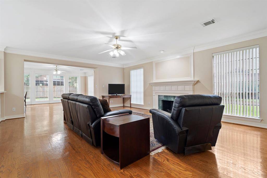 Gorgeous original hardwood floors flow seamlessly through the family room and sunroom, adding warmth and character.
