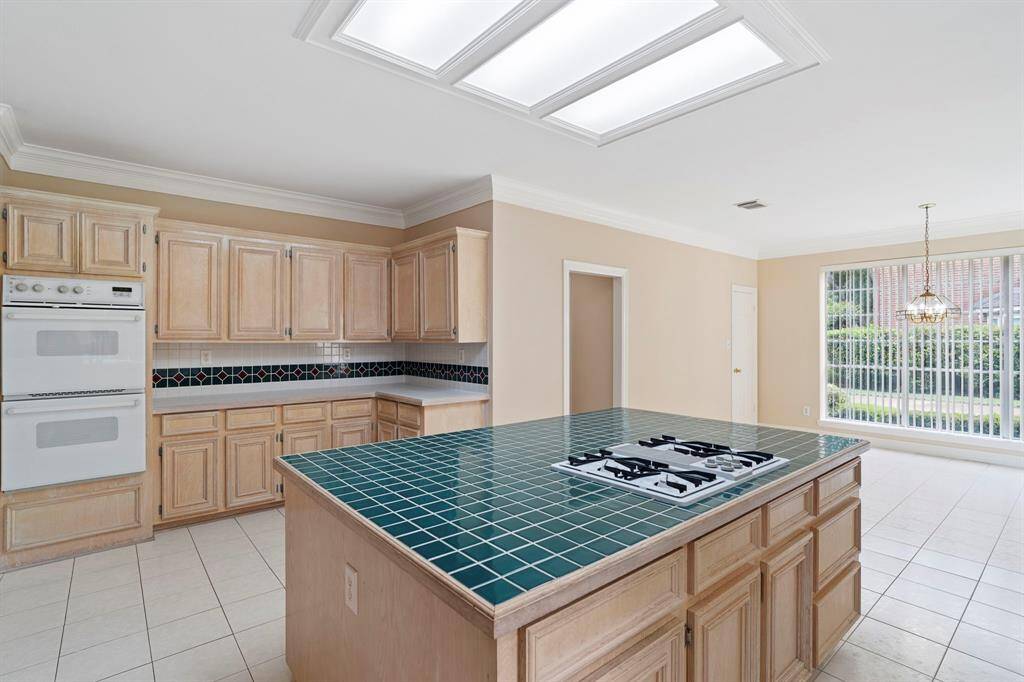 A spacious center island with a gas cooktop provides the perfect centerpiece for entertaining—offering ample prep space, storage, and effortless flow for gatherings.