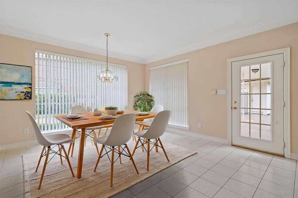 A delightful breakfast area, surrounded by floor-to-ceiling windows, offers abundant natural light and seamless access to the private patio and backyard—creating the perfect spot to start your day.