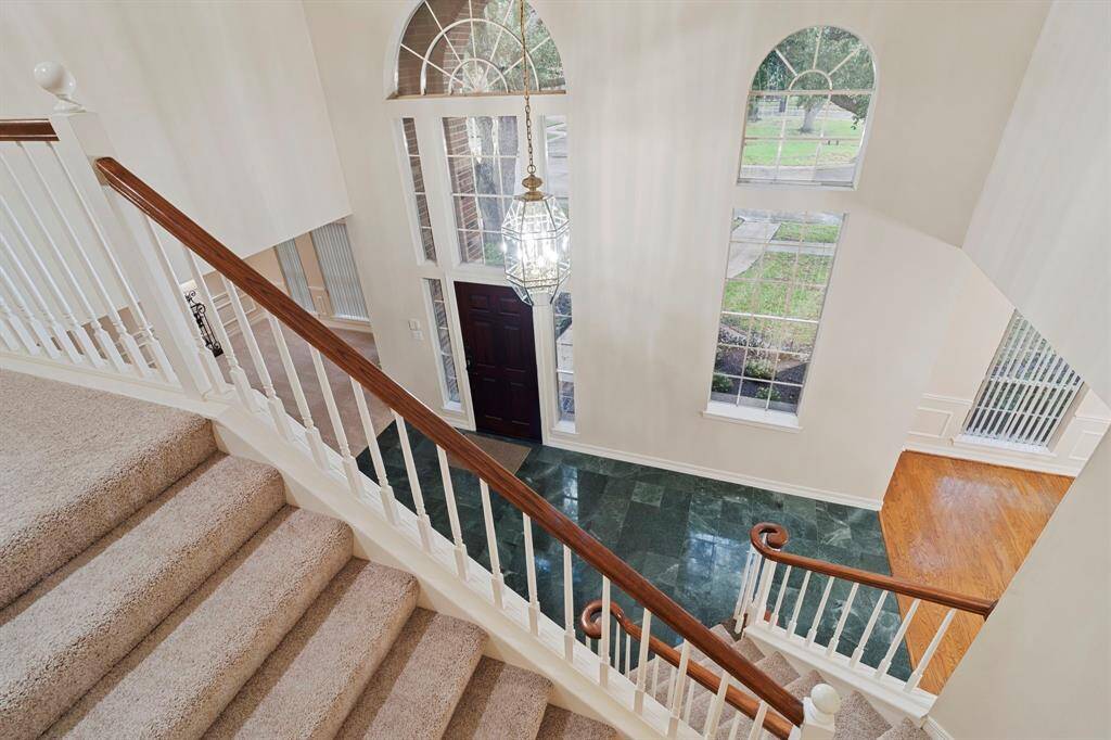 Graceful lunette windows at the front of the home add a distinctive architectural charm, allowing soft natural light to filter in while enhancing the home’s curb appeal with their elegant, curved design.