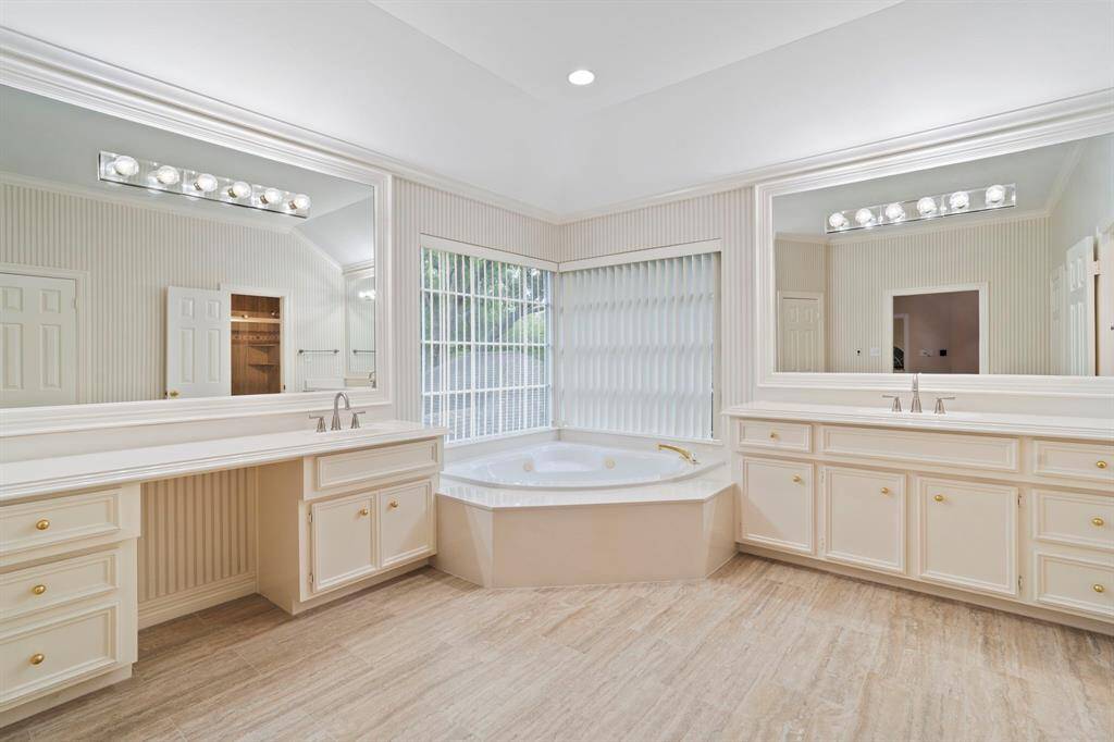 The spa-like en suite bathroom is a luxurious retreat, featuring dual oversized vanities, a dedicated make-up area, a jetted soaking tub, and a spacious walk-in shower. Thoughtfully designed for both comfort and convenience, the space also includes a linen closet and dual walk-in closets for ample storage.