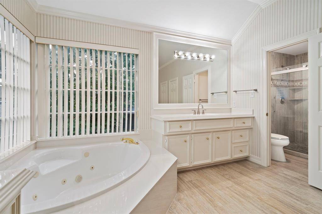 A private water closet features a toilet and walk-in shower, offering added comfort and privacy within the en suite bath.