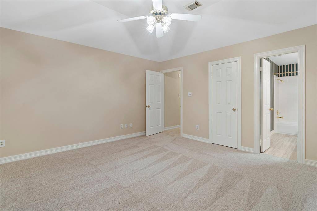 Another secondary bedroom boasts a vaulted ceiling and its own private en suite full bathroom, offering a comfortable and self-contained retreat for guests or family members.