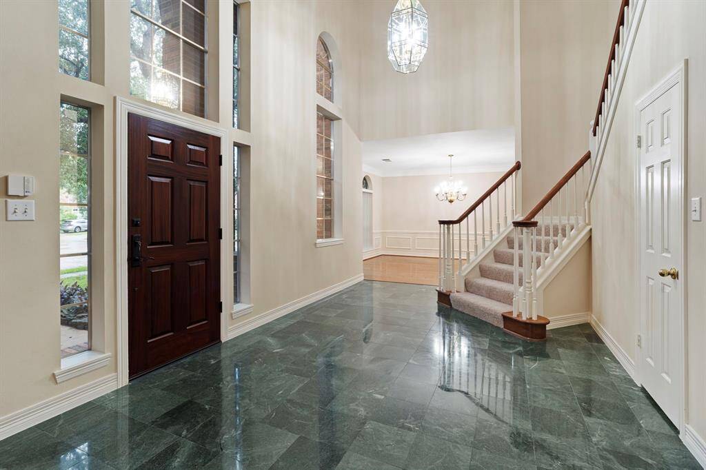From the moment you arrive, you’re greeted by a custom solid African Mahogany front door, opening into a soaring two-story formal entryway that sets the tone for the elegance within.