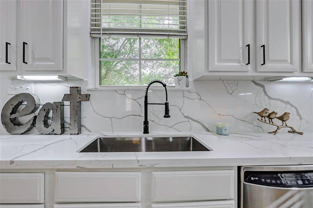 Washing dishes here has never been more fun! Huge single basin sink, sleek black faucet, and a view that makes you feel like you live in a killer tree house!