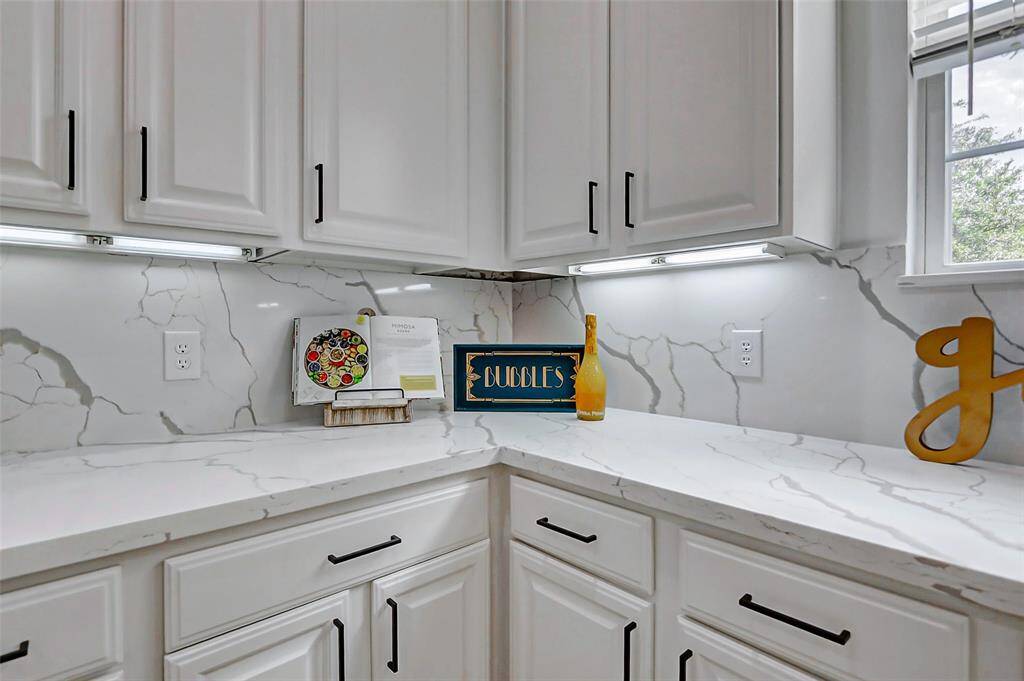 A luminous culinary space where sleek white finishes, oversized windows, and striking black accents create a magazine-worthy look that’s as timeless as it is stylish.