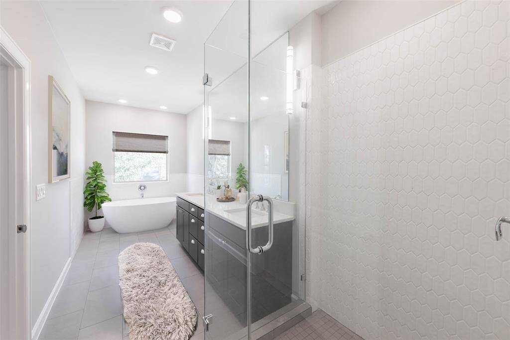 Spectacular pimary bath has freestanding tub,  frameless glass shower doors, expanded vanity with two sinks and Moen plumbing fixtures. (virtally staged)