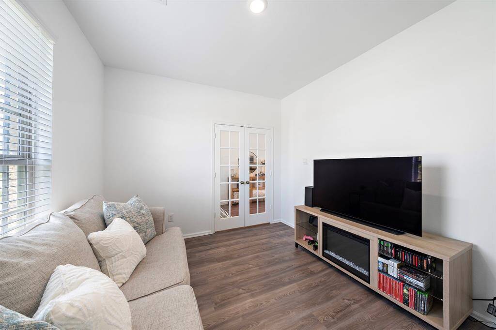 This room, located just off the entryway, can be used as a home office, flex space, or den, and it offers privacy with beautiful French doors.