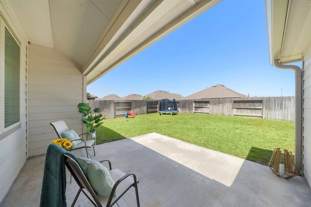 Enjoy a covered patio, overlooking a spacious, fenced backyard. The yard is well-maintained and offers a private outdoor space.