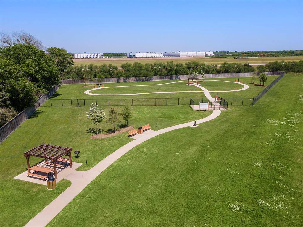 There is also a spacious, fenced dog park with winding paths, benches, and a shaded picnic area, ideal for outdoor activities and relaxation.