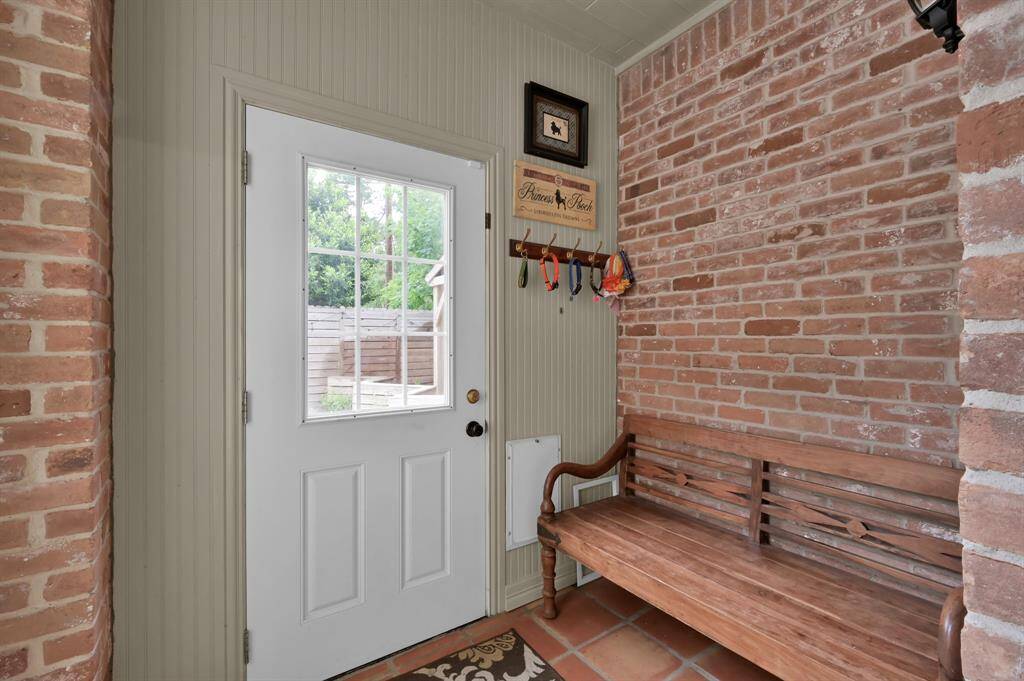 The pet room with access to the backyard via a pet door, and also has the wonderful exposed brick wall.