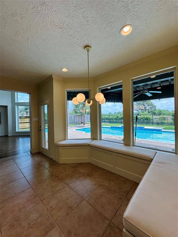 The breakfast area, bathed in sunlight, offers seamless connectivity to the kitchen, family room, and pool, creating an inviting space for both relaxation and entertainment.