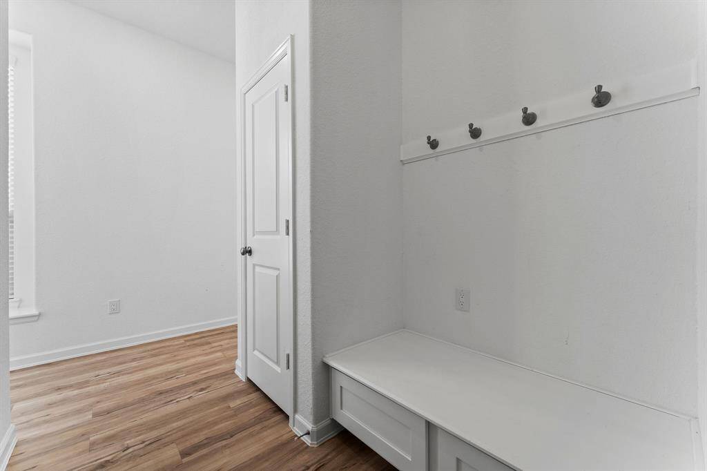 Conveniently located just off the garage, this stylish mud area is the perfect drop zone for daily essentials. Thoughtfully designed with a bench seat, four hooks for coats and backpacks, and cabinet storage for shoes, it helps keep your home neat and organized from the moment you walk in.