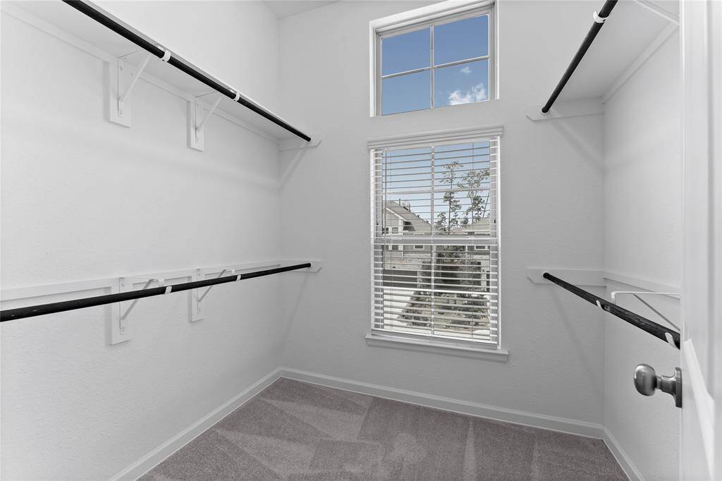 There will be no fighting for closet space with this large walk-in closet with ample hanging space and large sunny window.