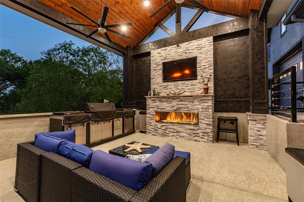 Host unforgettable gatherings in the lavish 18' x 17' sunken outdoor living/kitchen space crowned by a 10' ceiling and adorned with a dramatic 10' tall travertine fireplace. Outfitted with a built-in TV and designed for seamless indoor-outdoor living, this elegant space redefines entertaining with sophistication and style.