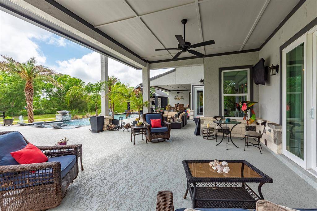 An additional covered outdoor living space, positioned poolside, seamlessly opens to the dining area through expansive sliding glass doors—creating a perfect flow for effortless indoor-outdoor living and entertaining.