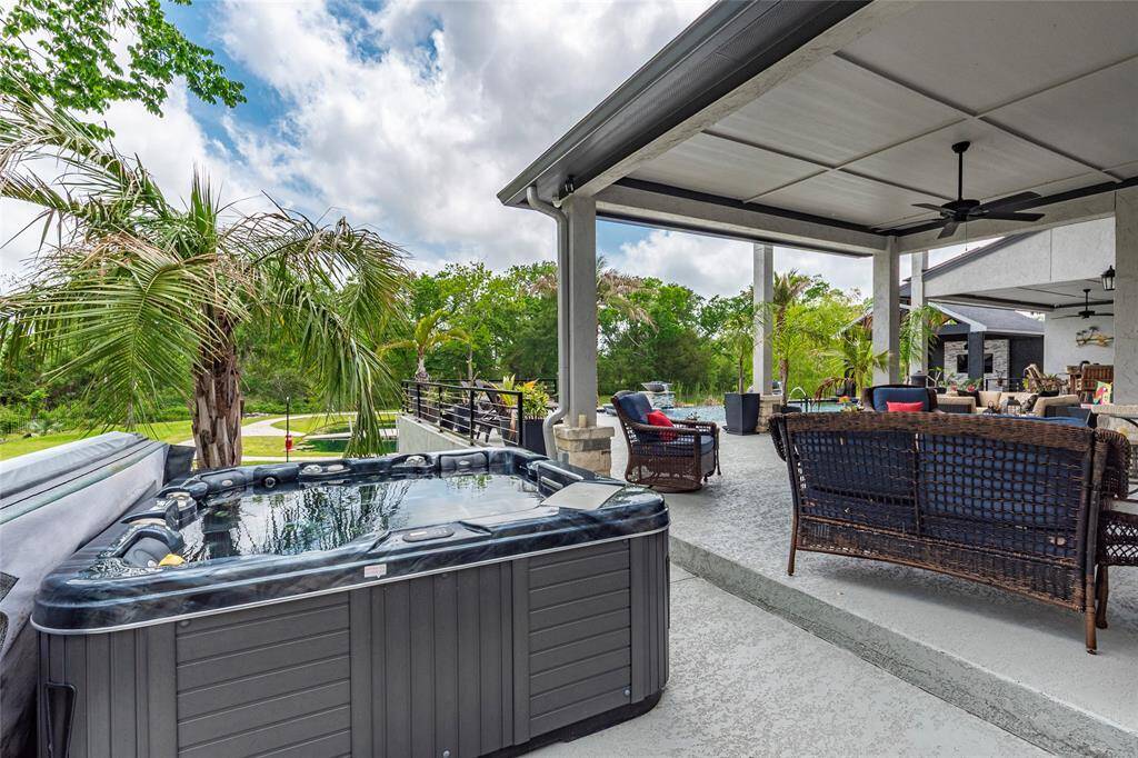 A separate spa, gracefully positioned near the covered outdoor living space, invites private relaxation with its soothing waters. This private retreat, along with the expansive cool deck, provides the ideal space for sunbathing and unwinding in ultimate comfort.